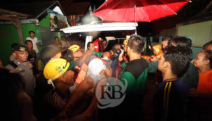 Petugas dibantu warga mengevakuasi lansia korban banjir di Dringu, Sabtu malam (9/3). (Zainal Arifin/ Radar Bromo)