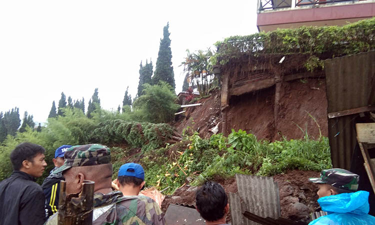 TANGANI: Sejumlah petugas gabungan dari kecamatan, Polsek, Koramil, Tagana, Kepala Desa dan BPBD Kabupaten Pasuruan dan warga mengevakuasi material longsor.