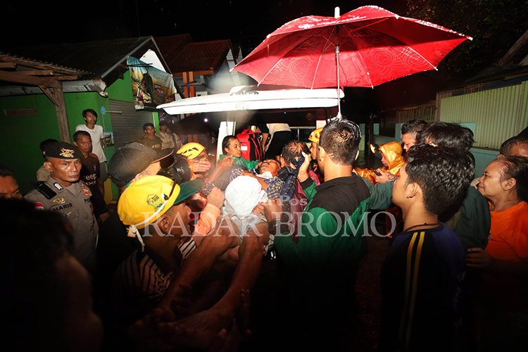 EVAKUASI: Sejumlah petugas dibantu warga mengevakuasi Agus, warga Desa Kedungdalem, yang mengalami patah tulang kaki akibat kejatuhan tembok dampak banjir, Sabtu (9/3) malam.