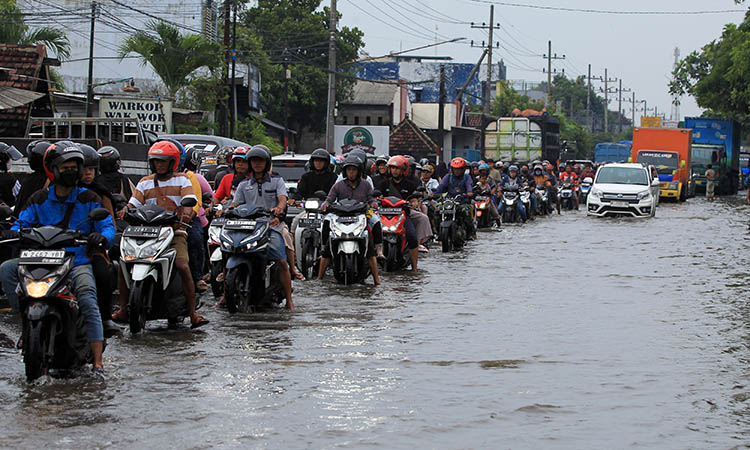 MACET: Antrean panjang kendaraan di jalan raya pantura, Desa Arjosari, Kecamatan Rejoso, karena genangan yang masih melanda, Senin (11/3).