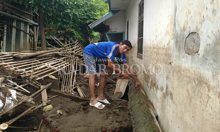 ROBOH: Pagar sebuah bangunan di Kecamatan Dringu ambrol akibat terjangan banjir, Sabtu (9/3) malam.