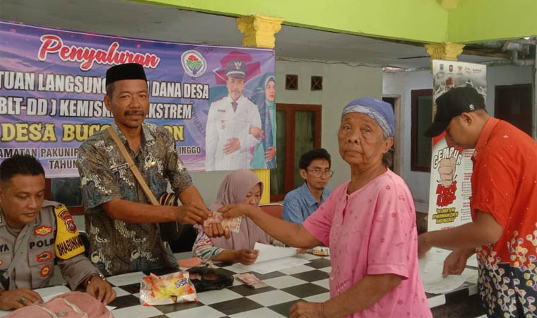 RINGANKAN BEBAN: Kepala Desa Bucor kulon, Abd Sukur memberikan BLT DD Kepada warganya.