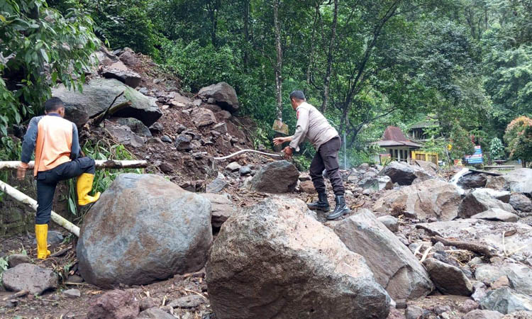 LONGSOR: Petugas membersihkan material longsor di Kecamatan Lumbang beberapa waktu lalu.