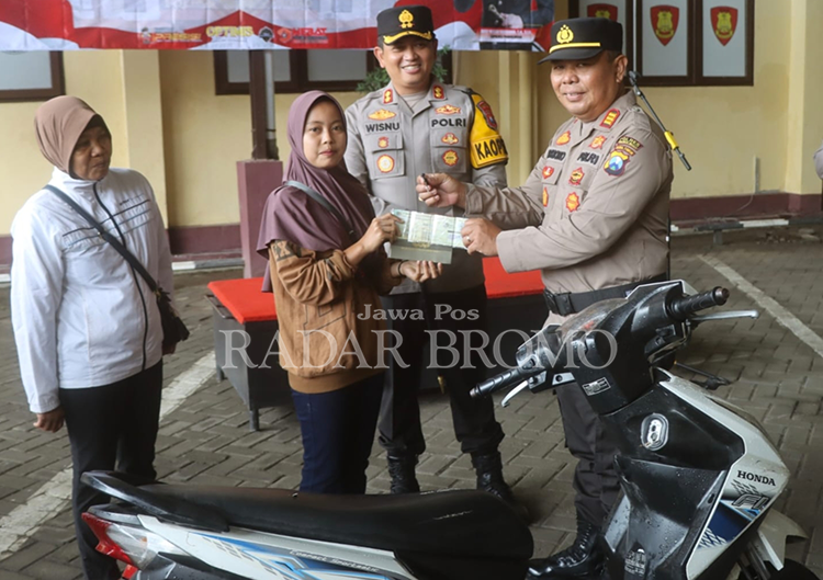 DIKEMBALIKAN: Kapolsek Lumbang AKP Suharsono mengembalikan motor Amalia Nur Hasanah di Mapolres Probolinggo.