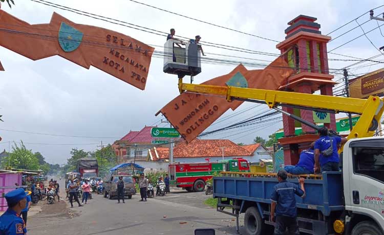 Petugas damkar menurunkan plang gapura perbatasan Kota Probolinggo yang patah di Wonoasih, Jumat (15/3). (Istimewa)