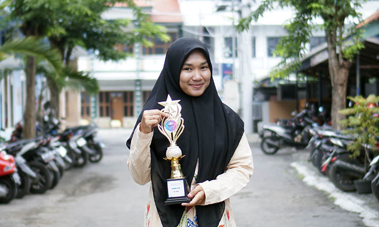 PIALA: Esa Bela 21, Mahasiswi Unhasa Genggong saat memegang tropi atau piala yang didapatnya sebagai juara 2 MTQ Nasional.