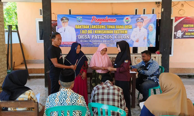 RINGANKAN BEBAN: Kepala Desa Patemon Kulon Muhammad (kiri kaus hitam) saat memberikan BLT DD kepada masyarakatnya.