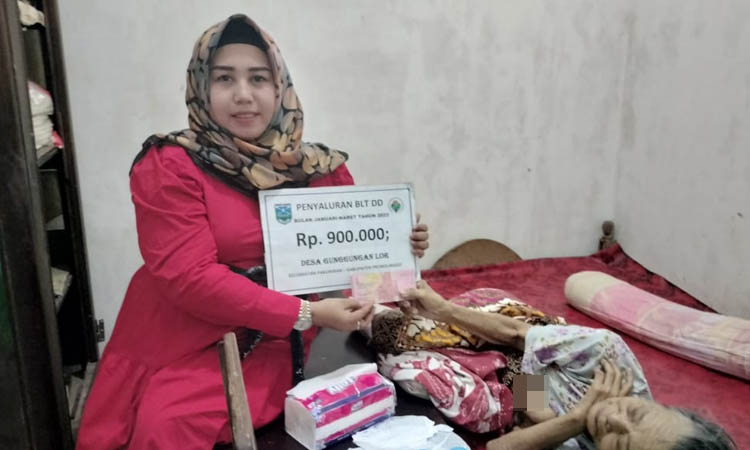 BERI: Kades Gunggungan Lor Sumiati (berkerudung) memberikan BLT DD kepada masyarakat penerima.