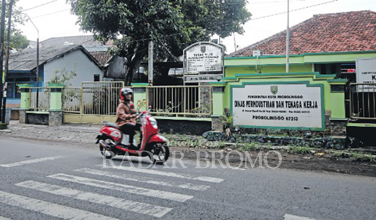 KANTOR: Pengendara motor melintas di depan Kantor Disperinaker Kota Probolinggo yang menyiapkan posko pengaduan THR.