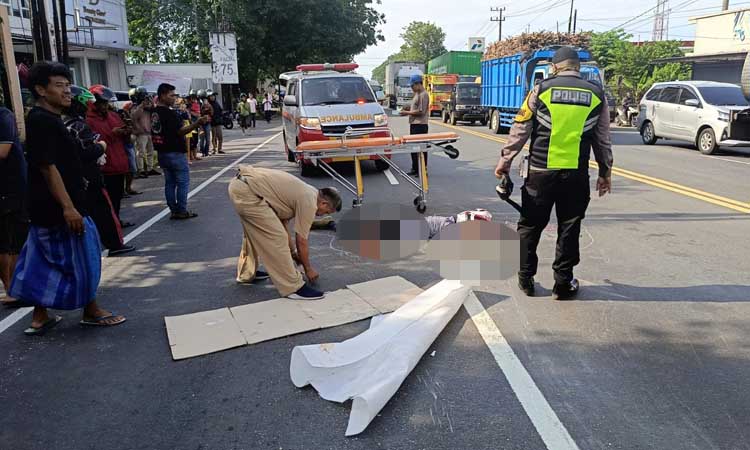 EVAKUASI: Jenazah korban ditutupi kain dan karton usai kecelakaan yang menimpanya.