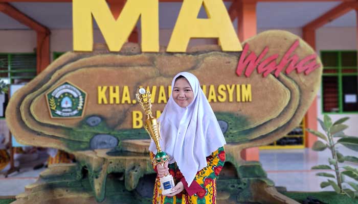 BERPRESTASI: Anif Isyna Fitri saat menunjukkan piala yang diraih. (M Busthomi/ Radar Bromo)
