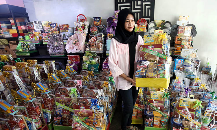 MENARIK: Sejumlah makanan ringan dan barang pecah belah disusun rapi hingga menjadi sebuah parsel lebaran di salah satu toko parsel di Jalan Panglima Sudirman.