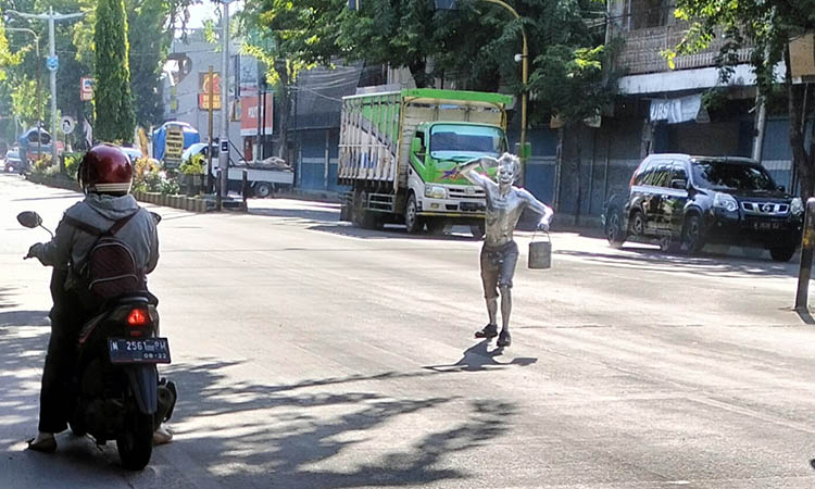 MUSIMAN: Pengemis manusia silver mangkal di sebuah lampu merah di Jalan Panglima Sudirman Kraksaan. Jumlah mereka tambah banyak selama Ramadan.