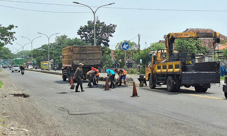 DITAMBAL: Penambalan jalan Raci, Kecamatan Bangil, yang mengalami kerusakan.