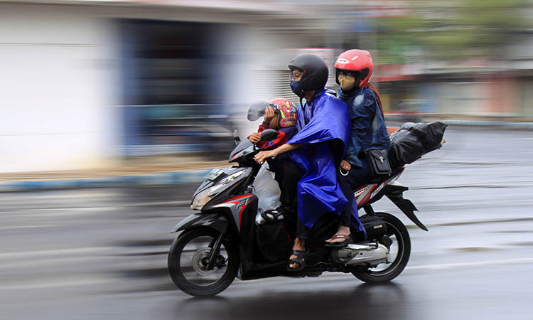 BASAH: Pemudik yang menerabas hujan demi bisa pulang ke kampung halaman. Jelang Lebaran, hujan masih akan melanda.
