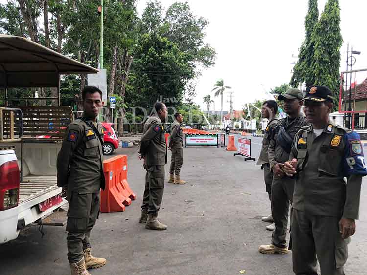 BERJAGA: Sejumlah anggota Satpol PP Kota Probolinggo berjaga di Jalan Ahmad Yani atau sisi selatan Alun-Alun Kota Probolinggo, Senin (22/4)