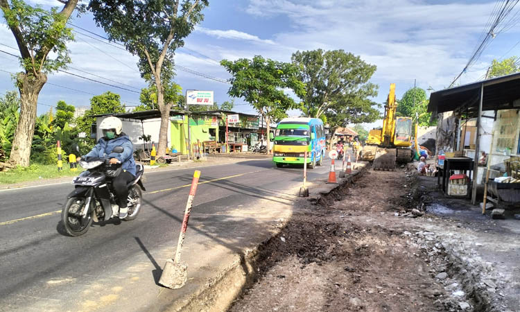 DIKERUK DULU: Alat berat mengeruk tepi jalan ruas jalan Pantura Desa Tamansari, Kecamatan Dringu. Ruas jalan ini akan dilebarkan sepanjang tiga kilometer.