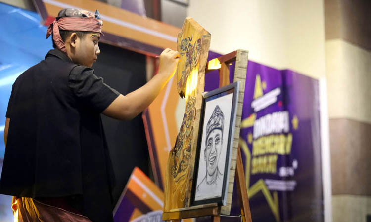 BIKIN TERKESIMA: Rizal Pahlevi Wibowo bakat Wood Painting dari SMPN 1 Kraksaan sedang tampil.