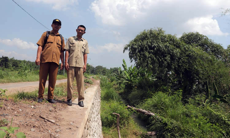 CEK TPT: Bendahara Desa Zainullah (kiri) bersama Sekdes Sumberkatimoho, Soleh melihat TPT yang dibangun tahun ini.