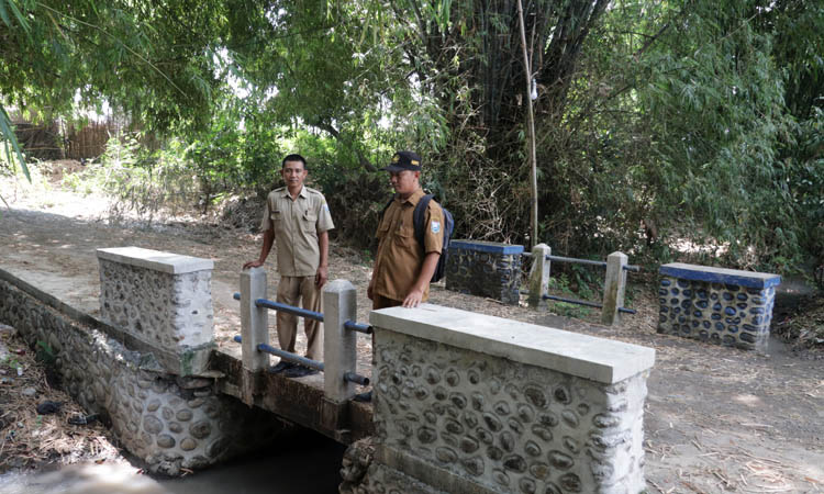 JALAN PENGHUBUNG: Bendahara Desa Zainullah (kanan) bersama Sekdes Sumberkatimoho, Soleh melihat kondisi jembatan yang dibangun tahun ini.
