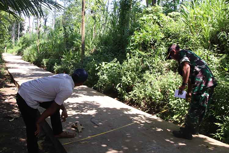 RABAT BETON: Batuud Koramil Leces Peltu Bambang Dwi Asmoro bersama Pendamping Teknik Infrastruktur Desa Ahmad Faisol Tanjung mengecek jalan rabat beton di Dusun Drandang.