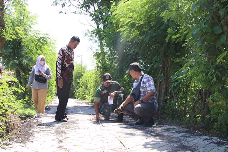 LEBIH BAIK: Batuud Koramil Leces Peltu Bambang Dwi Asmoro bersama Staf Kecamatan Leces Yusuf mengecek hasil pavingisasi di Dusun Pandansari.