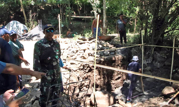 SEDANG DIKERJAKAN: Peltu Bambang Dwi Asmoro Batuud Koramil Leces saat di lokasi bersama Perangkat Kecamatan Leces di lokasi pembangunan jembatan di Dusun Buntes.
