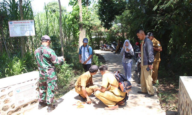HARUS LANCAR: Ahmad Faisol Tanjung Pendamping Teknik Infrastruktur Desa dan Perangkat Desa Tigasan Kulon saat melakukan pengecekan gorong-gorong di RT 24/RW 06 Dusun Buntes.