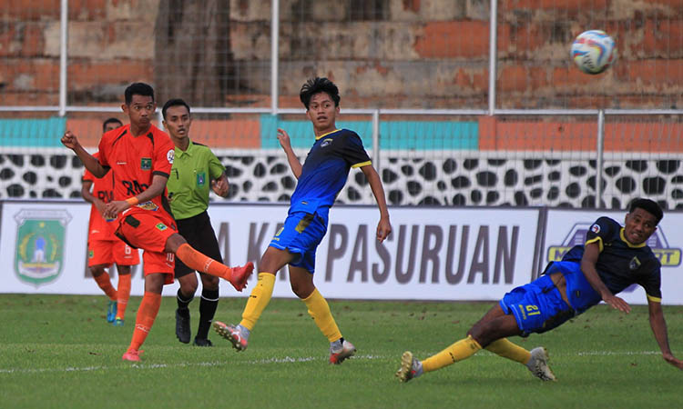 TENDANG: Penyerang Persekabpas Pasuruan, Novi Atmaja saat melesatkan bola untuk menghindari hadangan pemain Mangiwang FC.