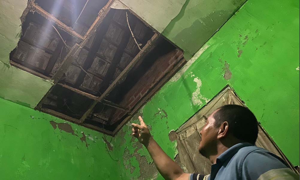 Panut menunjukkan atap rumahnya yang ambrol. Padahal lokasi rumahnya dengan ledakan sekitar 100 meter.