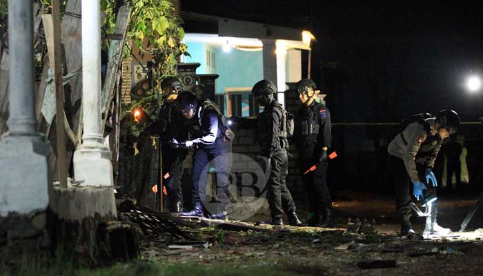 Petugas penjinak bom saat menyisir area gudang milik Ahmad alias Mat Cung titik lokasi ledakan, Jumat malam (10/5) di Ngemplakrejo, Panggungrejo, Kota Pasuruan. (Mokhamad Zubaidillah/ Radar Bromo)