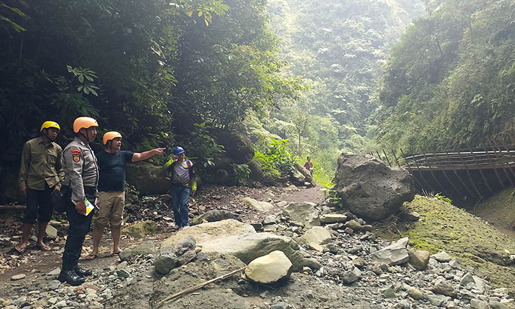 CEK LOKASI: Plt Kepala Diskopar Kabupaten Probolinggo Bambang Heri Wahyudi menunjuk jalur setapak menuju Air Terjun Madakaripura, yang lonsor. Sabtu (11/5), ia menyur