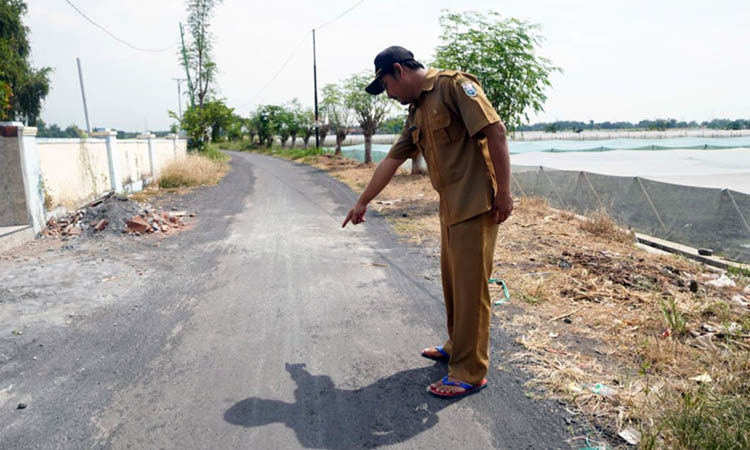 JALAN POROS: Bendahara Desa Tegalsiwalan Rudi Hariyanto mengecek jalan RT 4/RW 1, Dusun Krajan. Ada dua titik yang sudah selesai di bangun dengan konstruksi aspal lapen.