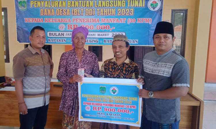 KELUARGA PENERIMA MANFAAT: Kepala Desa Kapasan Liyanto (kanan) memberikan BLTDD kepada warga kurang mampu.