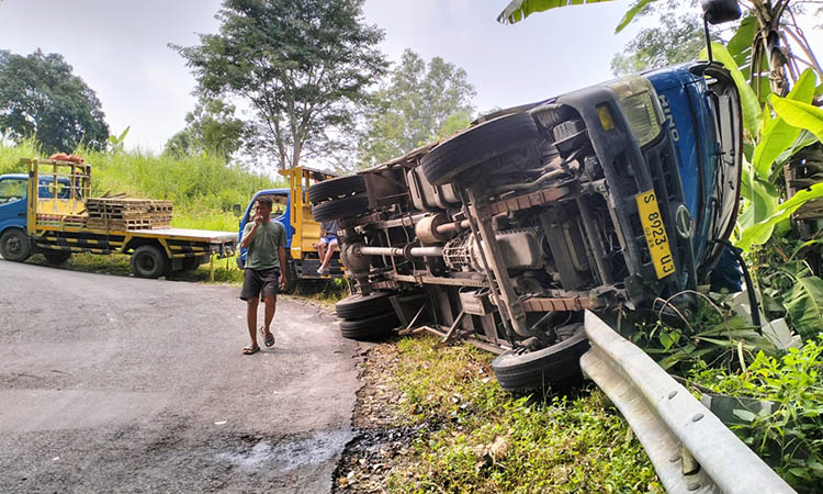 GULING: Truk pengangkut bata ringan yang terguling saat berada di turunan tajam, Desa Lumbangrejo, Kecamatan Prigen.