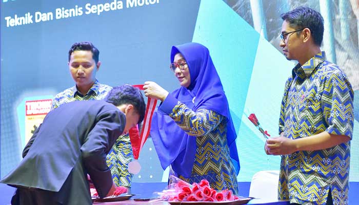 BANGGA: Kepala SMKN 2 Kraksaan Rr. Herlina Wulansari, S.Pd., M.M. mengalungkan gordon kepada 582 lulusannya.
