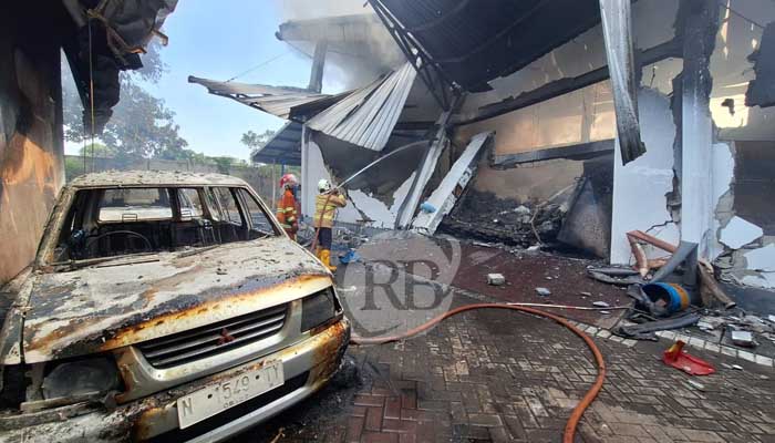 Petugas tengah melakukan pemadaman di pusat oleh-oleh Kaboki, Sukorejo, Kabupaten Pasuruan. Nampak sebuah mobil ikut terbakar. (M Busthomi/ Radar Bromo)