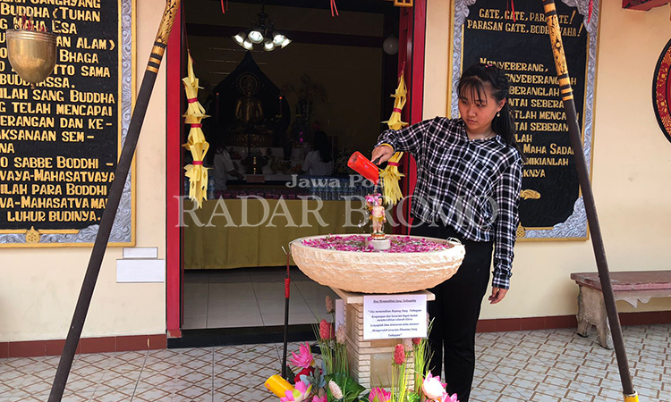 SUCI: Umat Buddha sedang memandikan rupang Buddha kecil di TTID Sumber Naga Kota Probolinggo, Kamis (23/5) siang, sebagai salah satu rangkaian memperingati Waisak.
