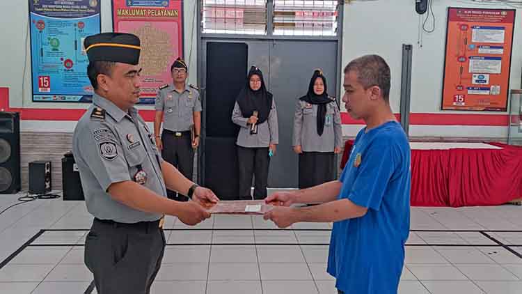 TERIMA REMISI: Kasi Binadik dan Giatja Lapas Kelas IIB Probolinggo Moh. Firman Arief Wijaya menyerahkan SK remisi kepada seorang warga binaan, Kamis (23/5).
