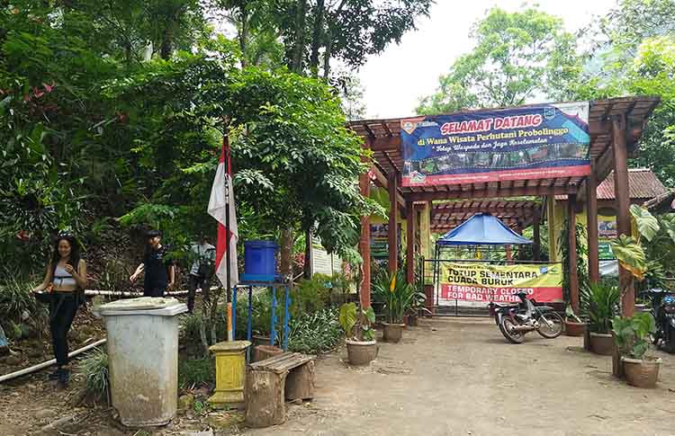MASIH TUTUP: Sejumlah pengunjung berwisata ke Air Terjun Madakaripura, Kecamatan Lumbang, melintasi jalur yang disediakan warga, Sabtu (25/5).