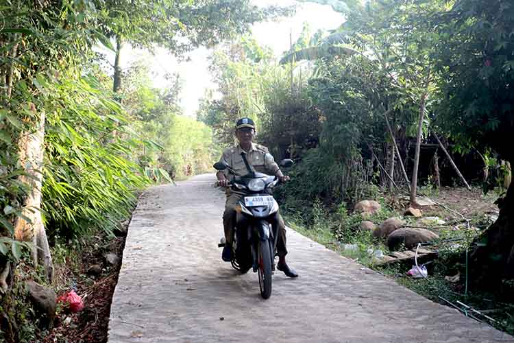 BANGUN: Kepala Desa Tandonsentul Sukri melintas di jalan RT 09/RW 03 Dusun Krandon, yang telah dirabat beton.