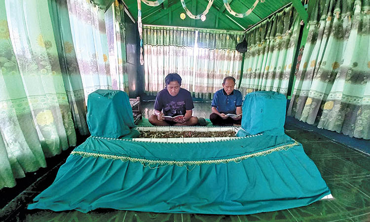 MAKAM: Santoso, 68 (kanan) dan Tohir Yanto, 37 (kiri) saat berdoa di ruangan pesarean Mbah Bujuk Adri, di Kelurahan Triwung Lor, Kecamatan Kademangan, Kota Probolinggo.