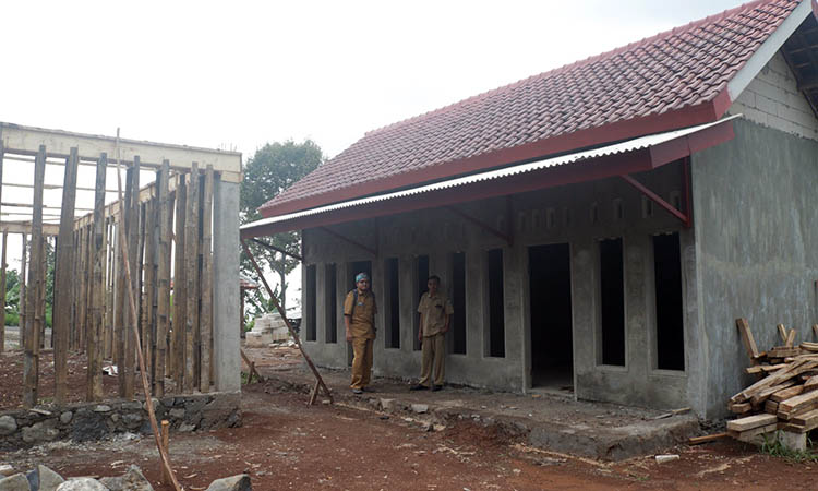 KOKOH: Sekretaris Desa Negororejo Syahril Fahrizal (pakai tas) mengecek pembangunan gedung pertemuan di RT 5/RW 3, Dusun Krajan.