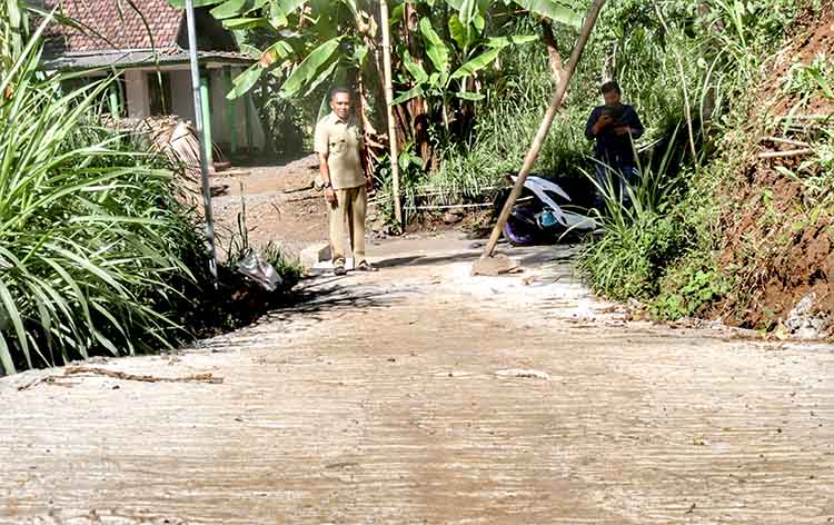 MULUS: Bendahara Desa Lambangkuning Mujiono mengecek jalan rabat beton di RT 14/RW 3, Dusun Kesut.
