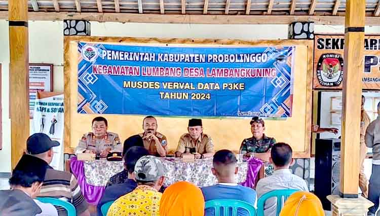 RAPAT: Camat Lumbang Saniwar (pegang mik), Kepala Desa Lambangkuning Timbul (berpeci), bersama Forkopimca Lumbang saat Musdes Verval Data P3KE di balai desa.