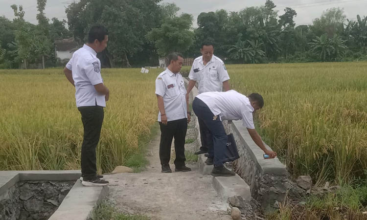 PROGRAM PERTAHANAN PANGAN: Kepala Desa Selogudig Wetan Bagus Budi Prayoga (kiri) mengecek pengerjaan pembangunan saluran irigasi yang ada di Dusun Asa