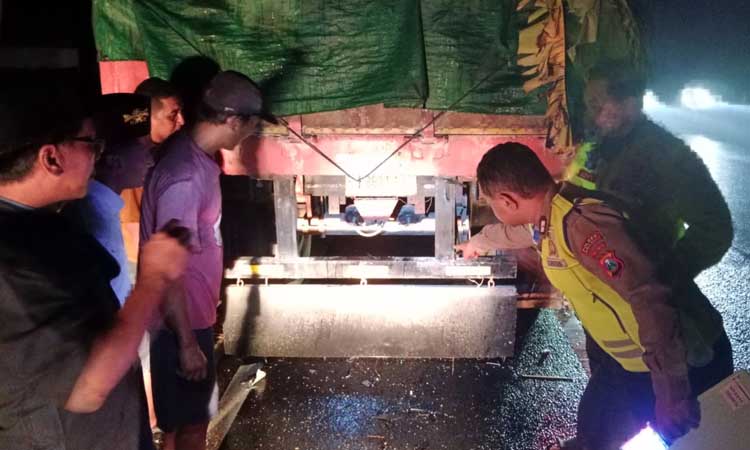 BARANG BUKTI: Polisi mengamati truk parkir yang ditabrak korban.