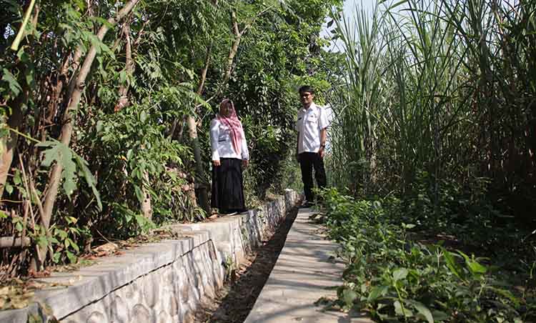 MAKIN KOKOH: Sekretaris Desa Alassumur Kulon Sulastri dan Operator Desa Alassumur Kulon Andri Dermawan di lokasi pembangunan irigasi sepanjang 120 meter di area persawahan di RT 02/RW 06 Dusun Kantor.