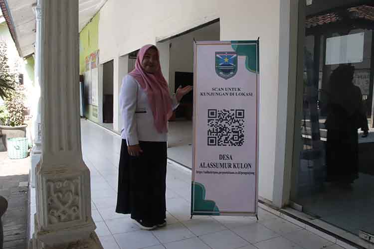 LAYANAN ONLINE: Sekretaris Desa Alassumur Kulon Sulastri menunjukkan banner aplikasi pelayanan masyarakat secara online di Kantor Desa Alassumur Kulon.