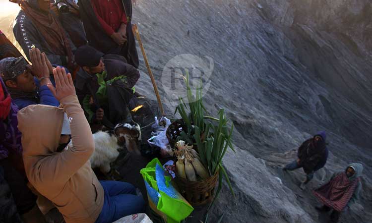 Warga Hindu suku Tengger Bromo sedang melakukan ritual larung sesaji pada puncak perayaan Yadnya Kasada 1946 Saka di bibir kawah Gunung Bromo, Sabtu (22/6/2024) pagi.